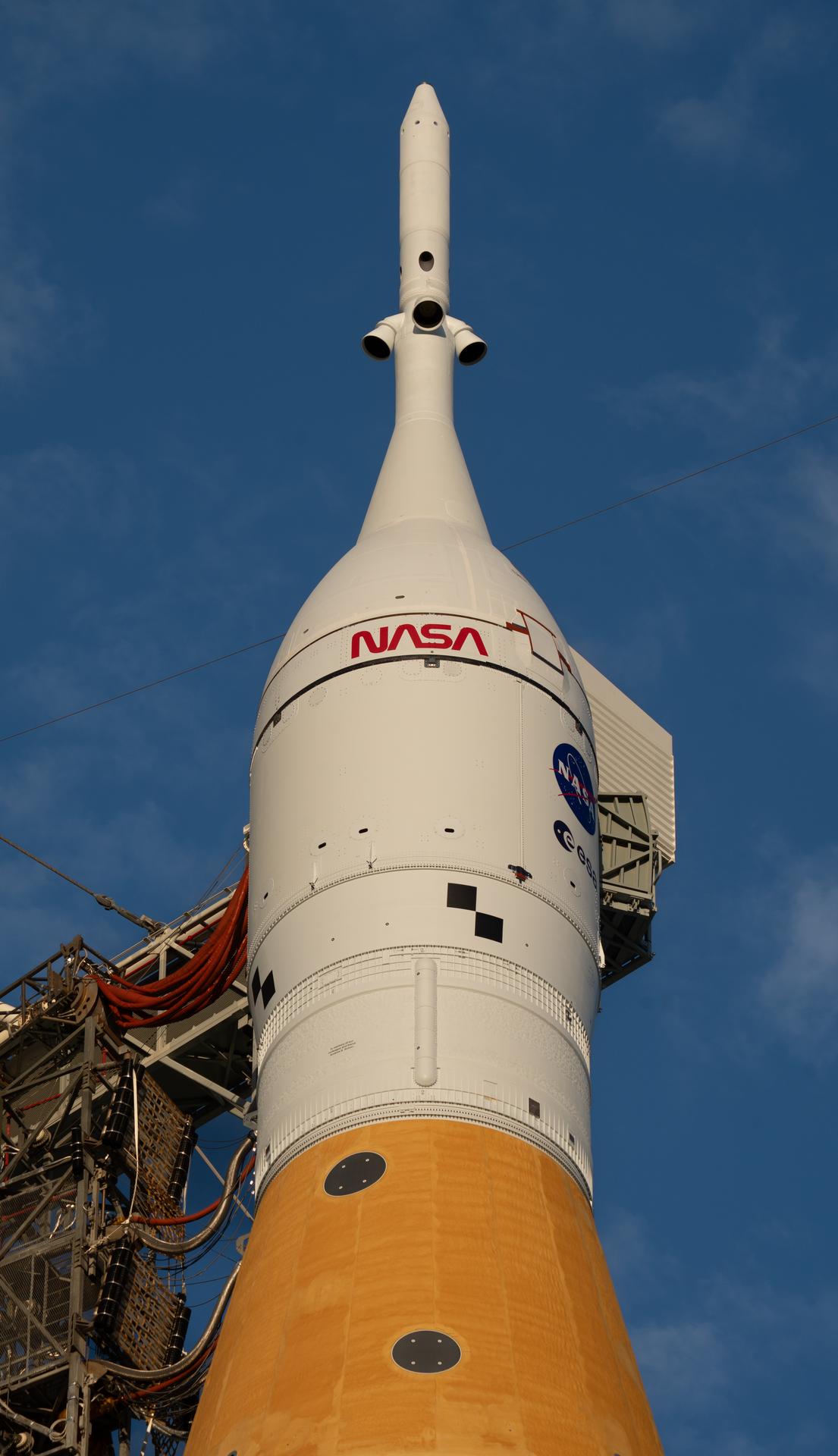 A side view shows the SLS (Space Launch System) Launch Vehicle Stage Adapter, Orion Stage Adapter, Orion spacecraft, and Launch Abort System of NASA’s Artemis II rocket at Launch Complex 39B at NASA’s Kennedy Space Center. The Artemis II test flight will take Commander Reid Wiseman, Pilot Victor Glover, and Mission Specialist Christina Koch from NASA, and Mission Specialist Jeremy Hansen from the CSA (Canadian Space Agency), around the Moon and back to Earth.